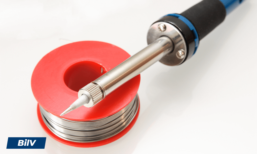 Lödpenna med smal spets placerad på en rulle tenntråd, idealisk för precisionslödning